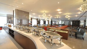 A modern hotel lobby with a buffet area, seating arrangements, and decorative lighting. - Kaohsiung International Plaza (Kaohsiung)