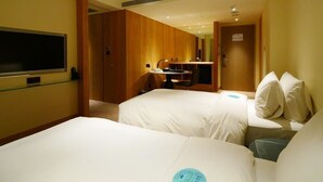 A hotel room with two beds, a TV, a desk, and a mirror. - Kaohsiung International Plaza (Kaohsiung)
