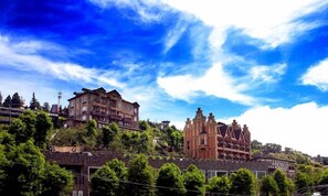 A historic building with multiple stories and a traditional architectural style, surrounded by lush greenery. - Florence Resort Villa (Ren'ai)