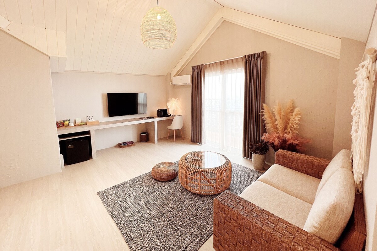 Una sala de estar moderna con un televisor de pantalla plana, un sofá, una mesa de centro y un comedor.