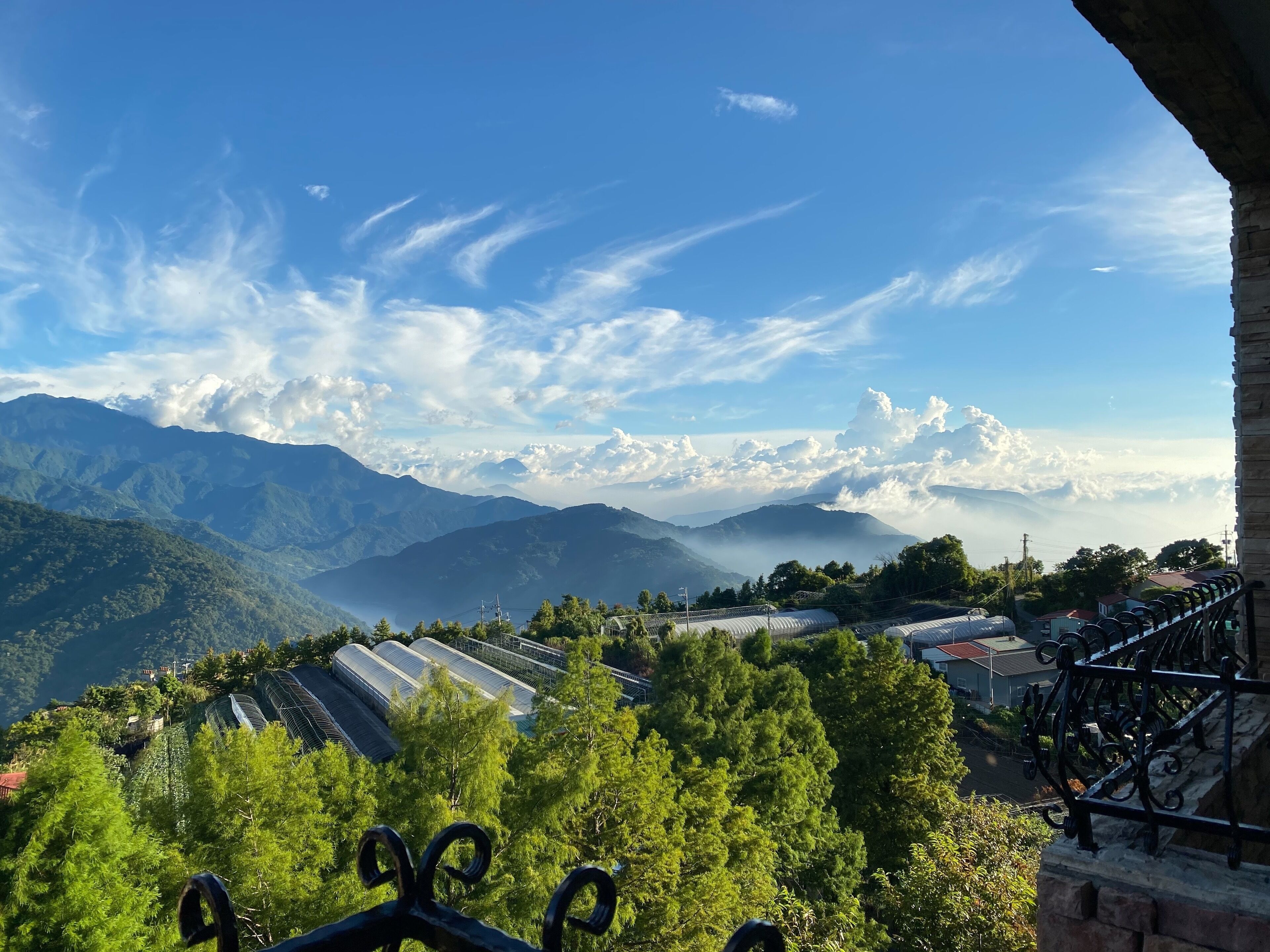 A mountainous landscape with a clear sky and a view of green hills and buildings.