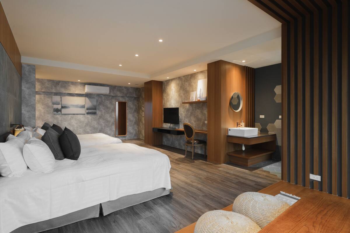 Quarto moderno com uma cama grande, uma escrivaninha e banheiro.