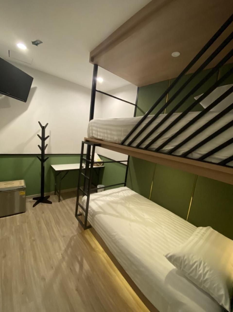 A bunk bed room with a desk and a coat rack.