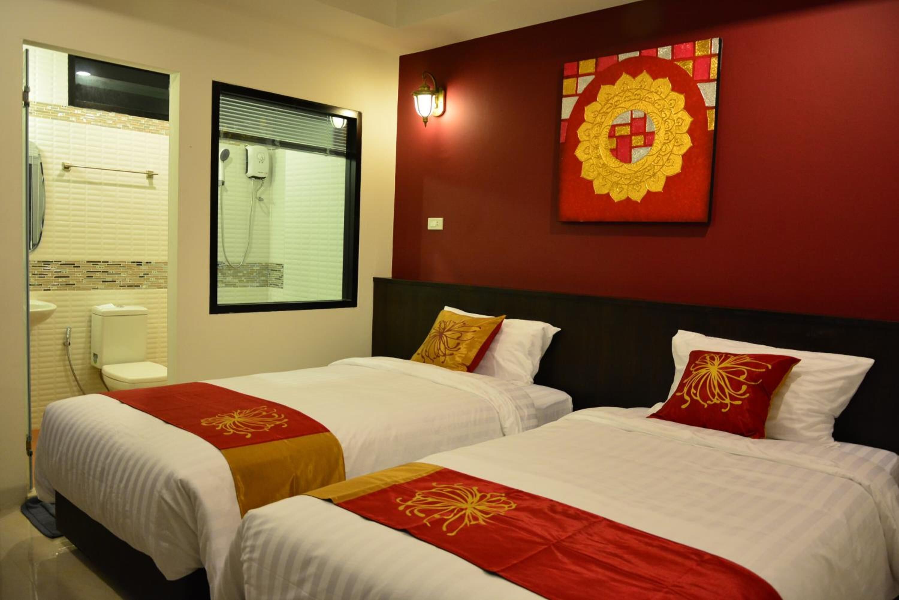 A hotel room with two beds, a bathroom, and a decorative wall piece.