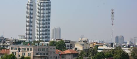 Paisagem urbana com arranha-céus, casas residenciais e céu claro.
