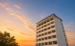 Ein mehrstöckiges Hotel mit Balkonen und einer flachen Dachterrasse.