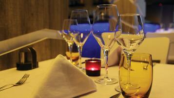 A table set with wine glasses, a candle, and cutlery.