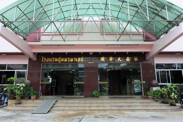A building with a glass entrance and potted plants in front.