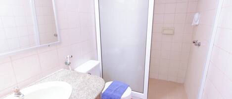 A bathroom with a sink, toilet, and shower area.