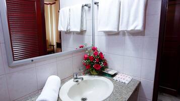 A bathroom with a white sink, a mirror, and a red door.