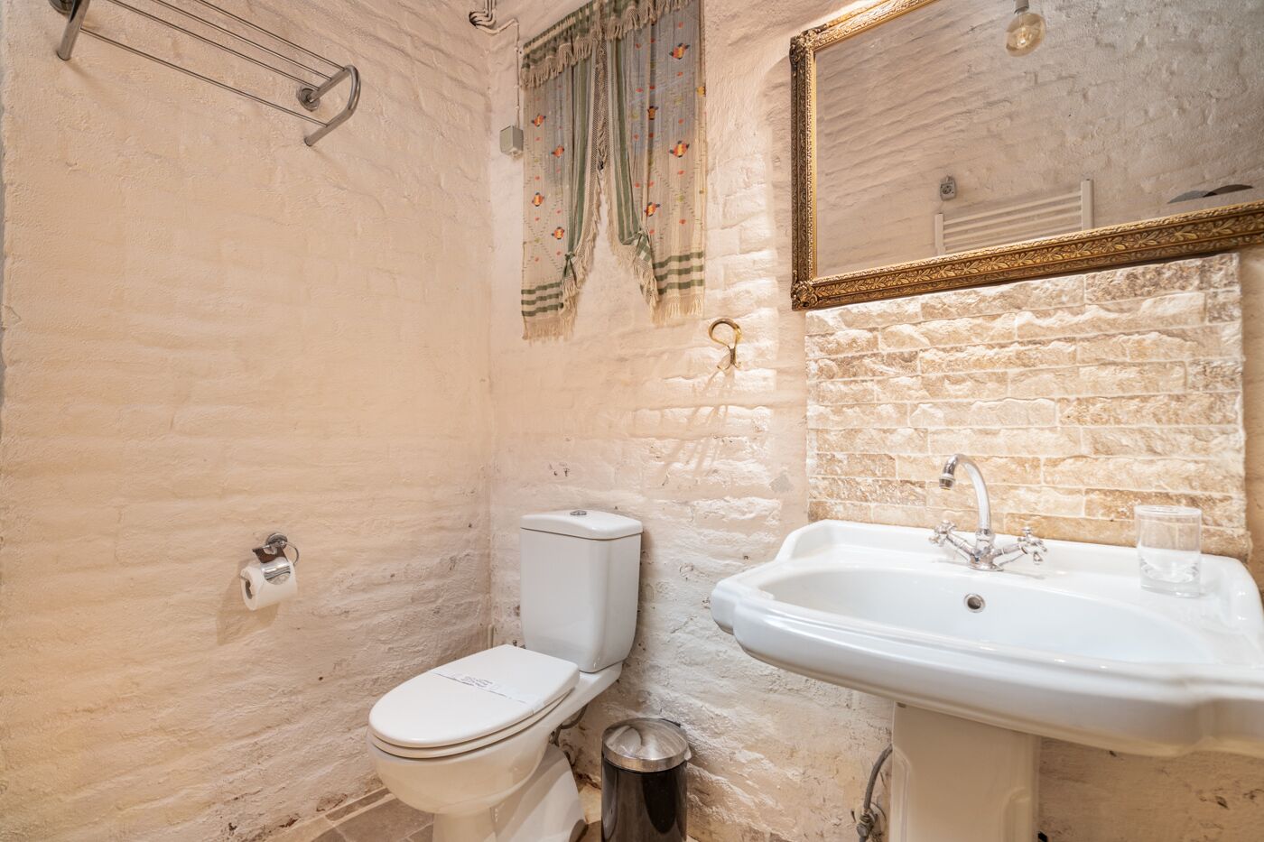 Une salle de bain avec des toilettes, un lavabo et un miroir.