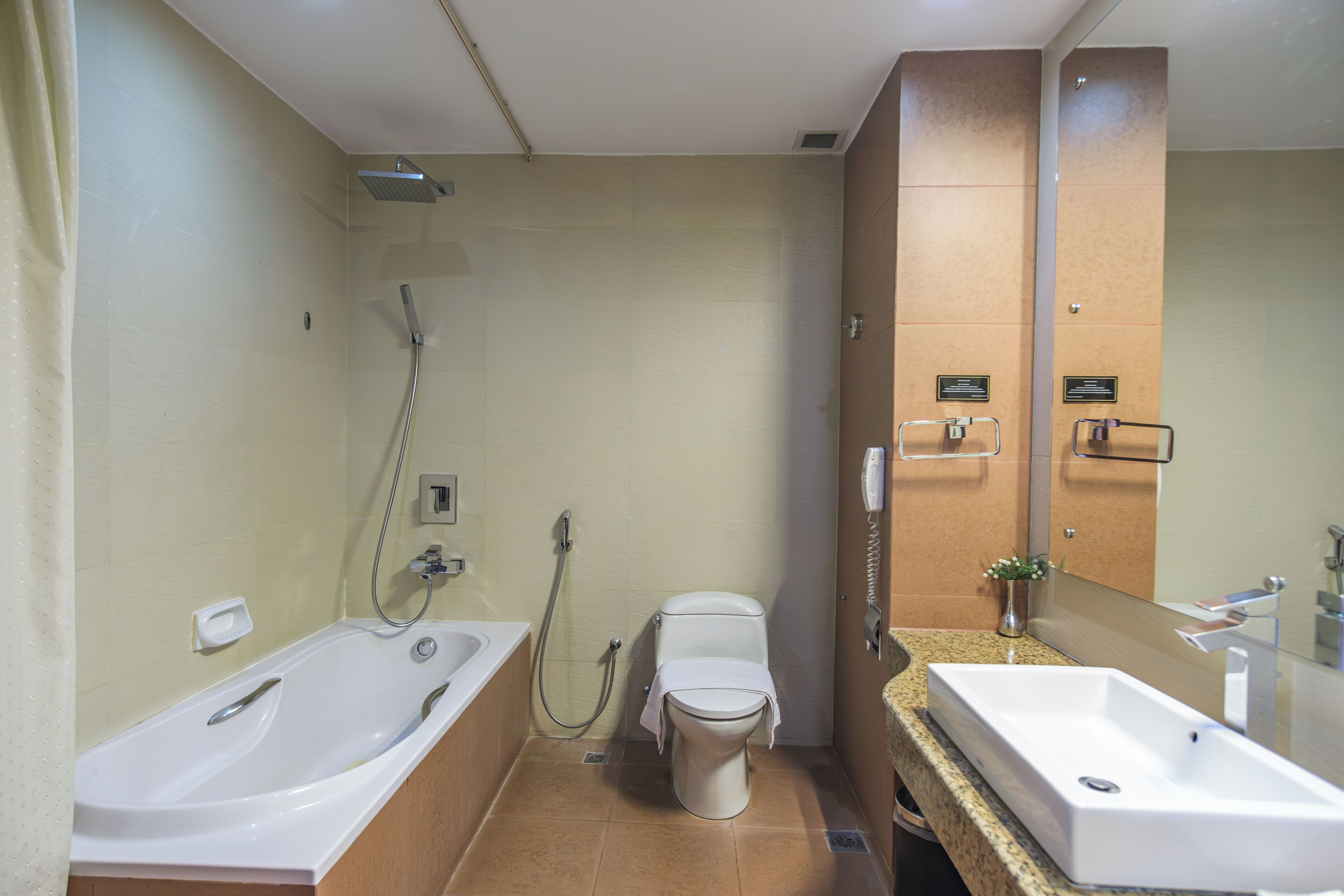 Ein modernes Badezimmer mit Badewanne, Toilette und zwei Waschbecken.