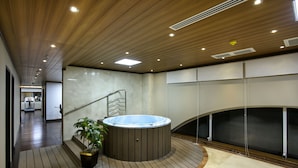 A modern indoor pool area with a hot tub, wooden flooring, and a staircase leading to another level. - Grand Sultan Tea Resort & Golf (Kamalganj)