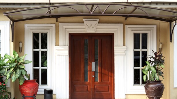 A front entrance with a wooden door, two windows, and potted plants. - The W Hotel (Lagos)