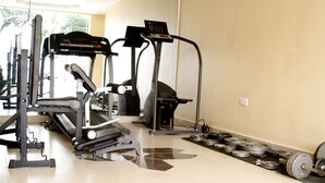A gym with exercise equipment, a patterned floor, and weights. - The W Hotel (Lagos)