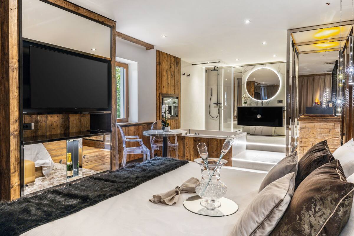 Een moderne woonkamer met een flatscreen-tv, een eethoek met een glazen tafel en een gezellige zithoek met een vachtkleed.
