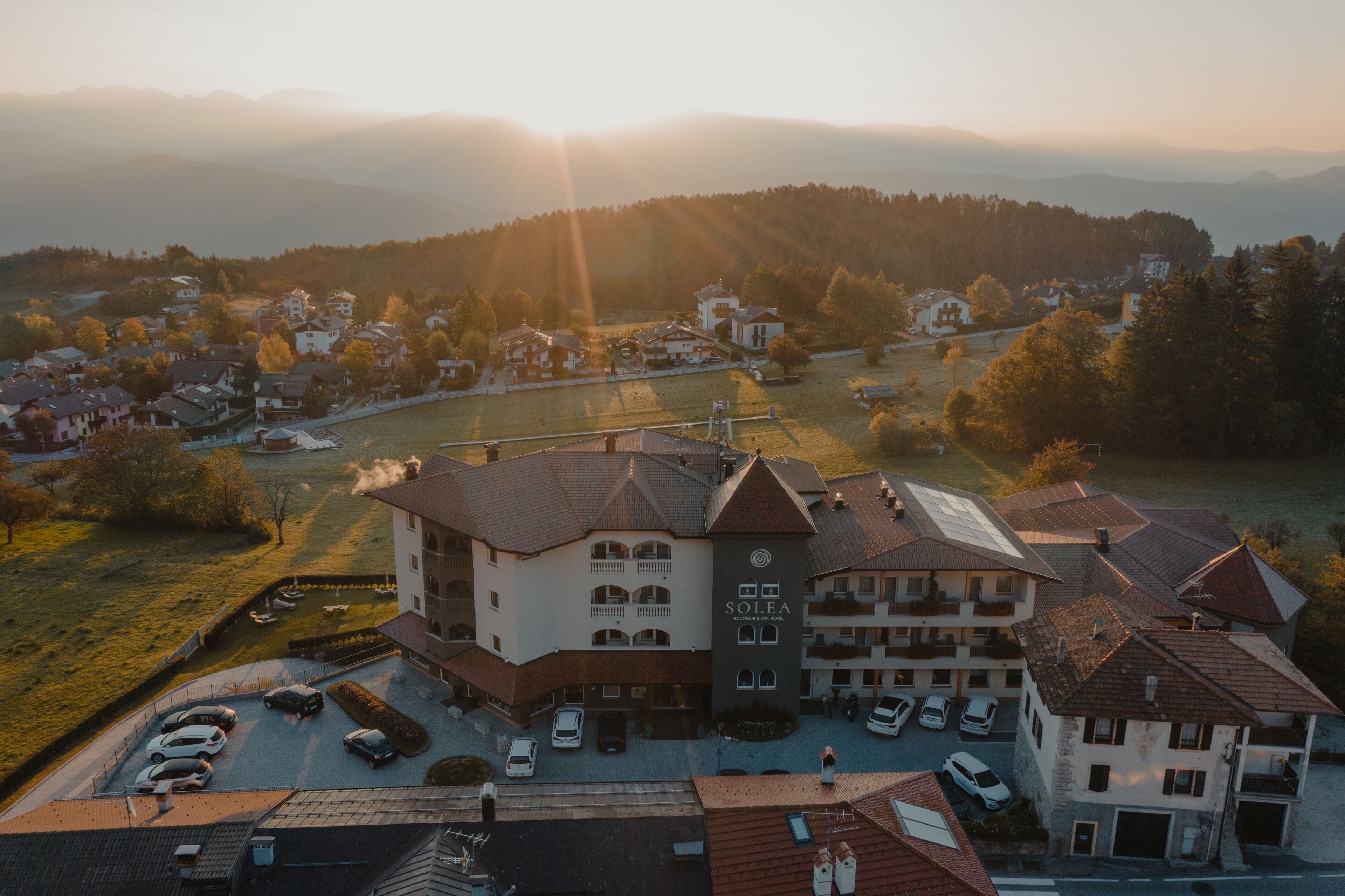 Un hotel con varias construcciones, un estacionamiento y vistas del paisaje circundante.