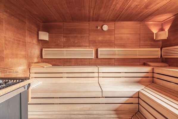 A sauna with wooden benches and a wooden ceiling.