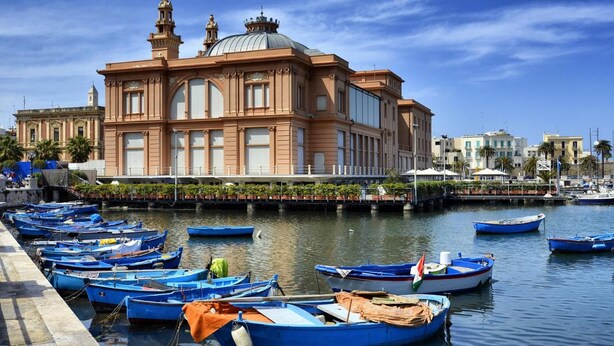 Un bâtiment situé au bord de l’eau, doté d’un grand dôme et de nombreuses fenêtres, et entouré d’un port de plaisance où sont amarrés de nombreux petits bateaux.