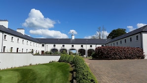A large, white building with multiple windows and a central entrance. - New Forest Golf Club Apartments (Tyrrellspass)