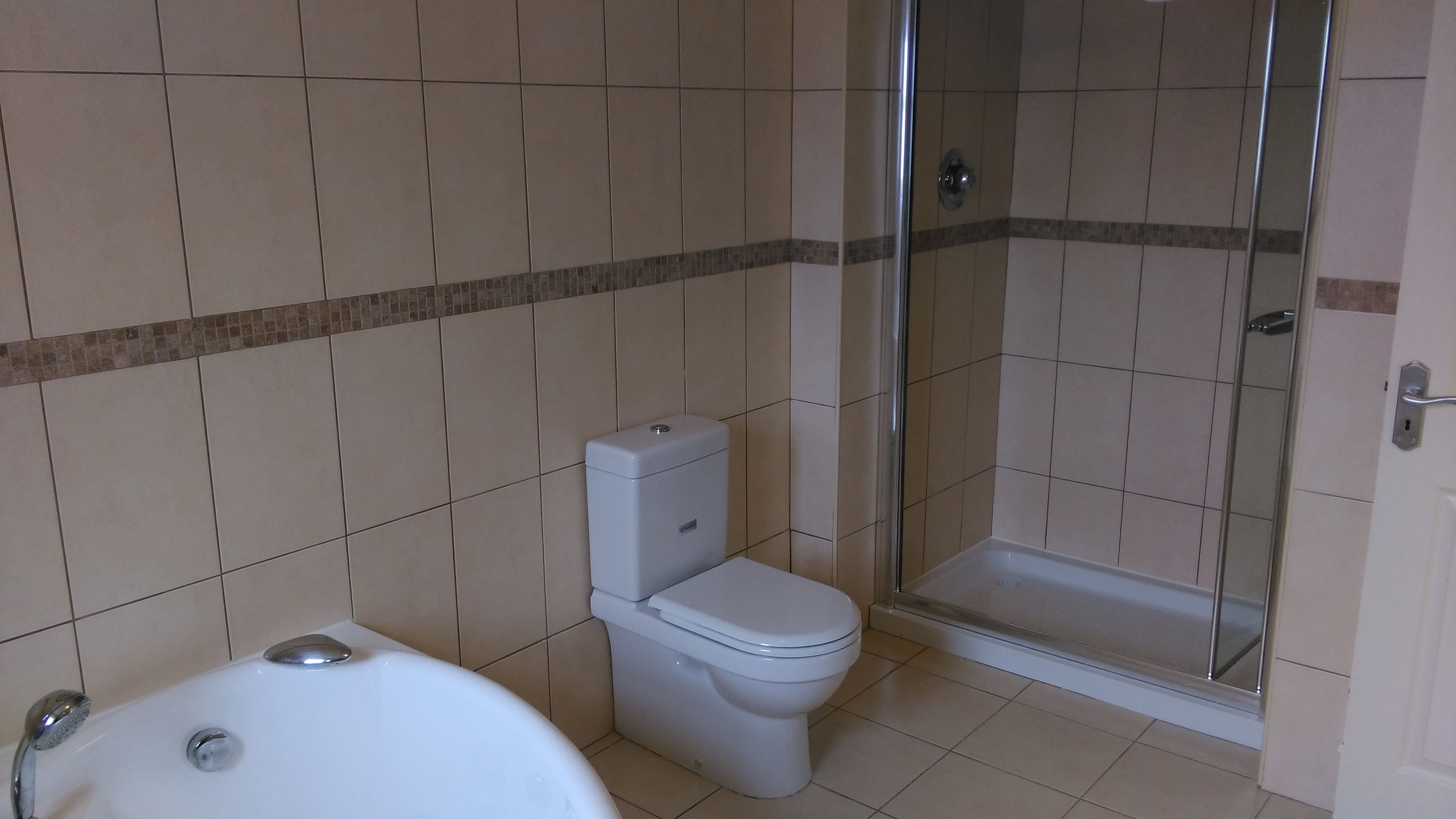 Ein Badezimmer mit Toilette, Badewanne und Duschkabine.