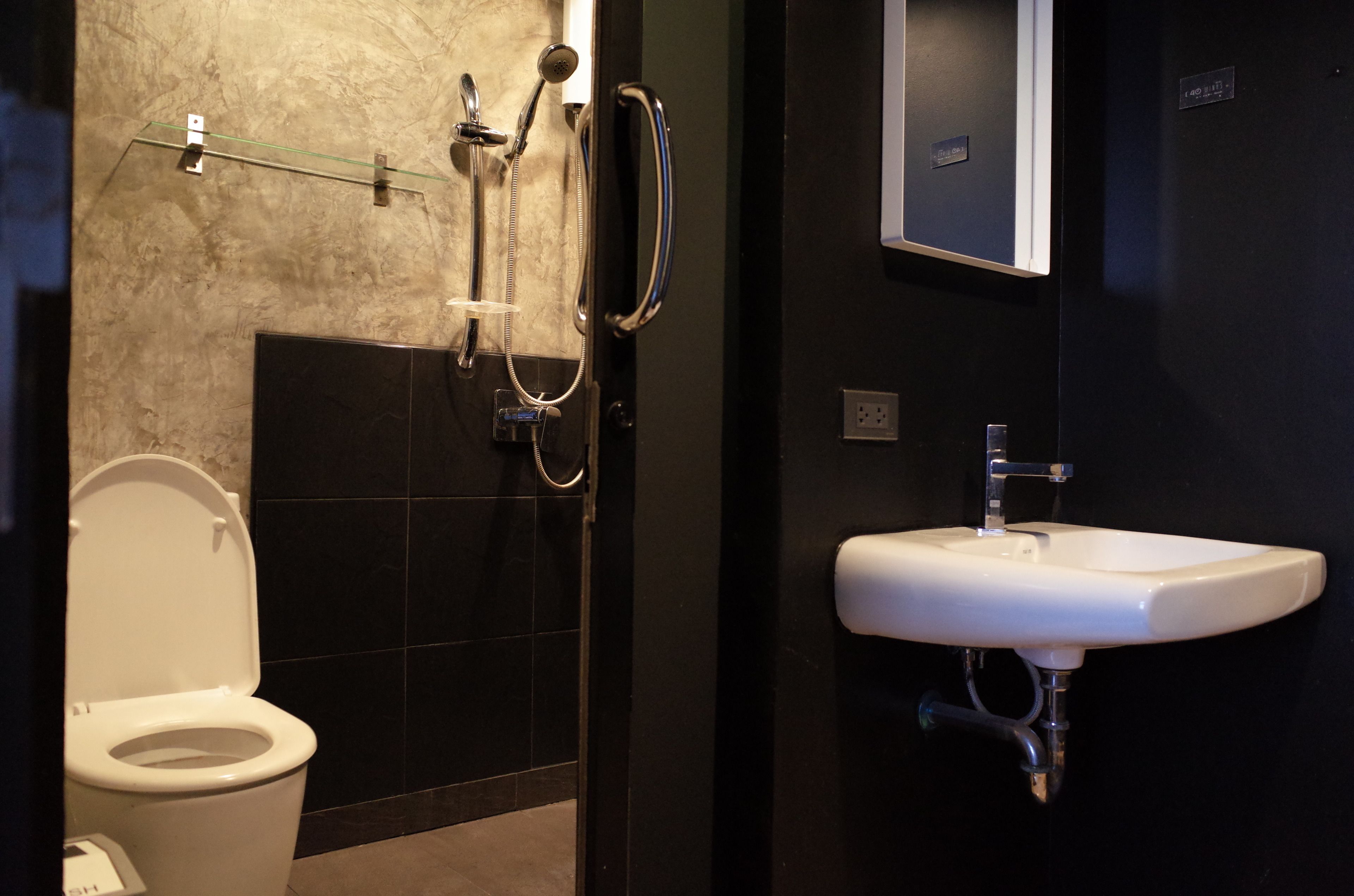Un baño con inodoro, ducha con puerta de vidrio y lavamanos.