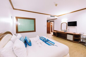 A hotel room with a bed, a desk, a TV, and a bathroom visible through an open door. - Chumphon Gardens Hotel (Chumphon)