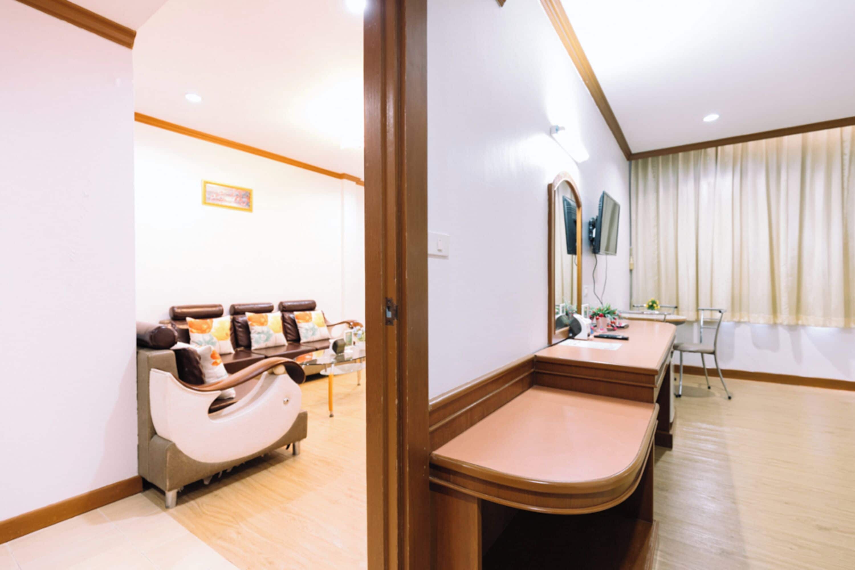 Een kamer met een massagestoel, een bureau en een grote spiegel.