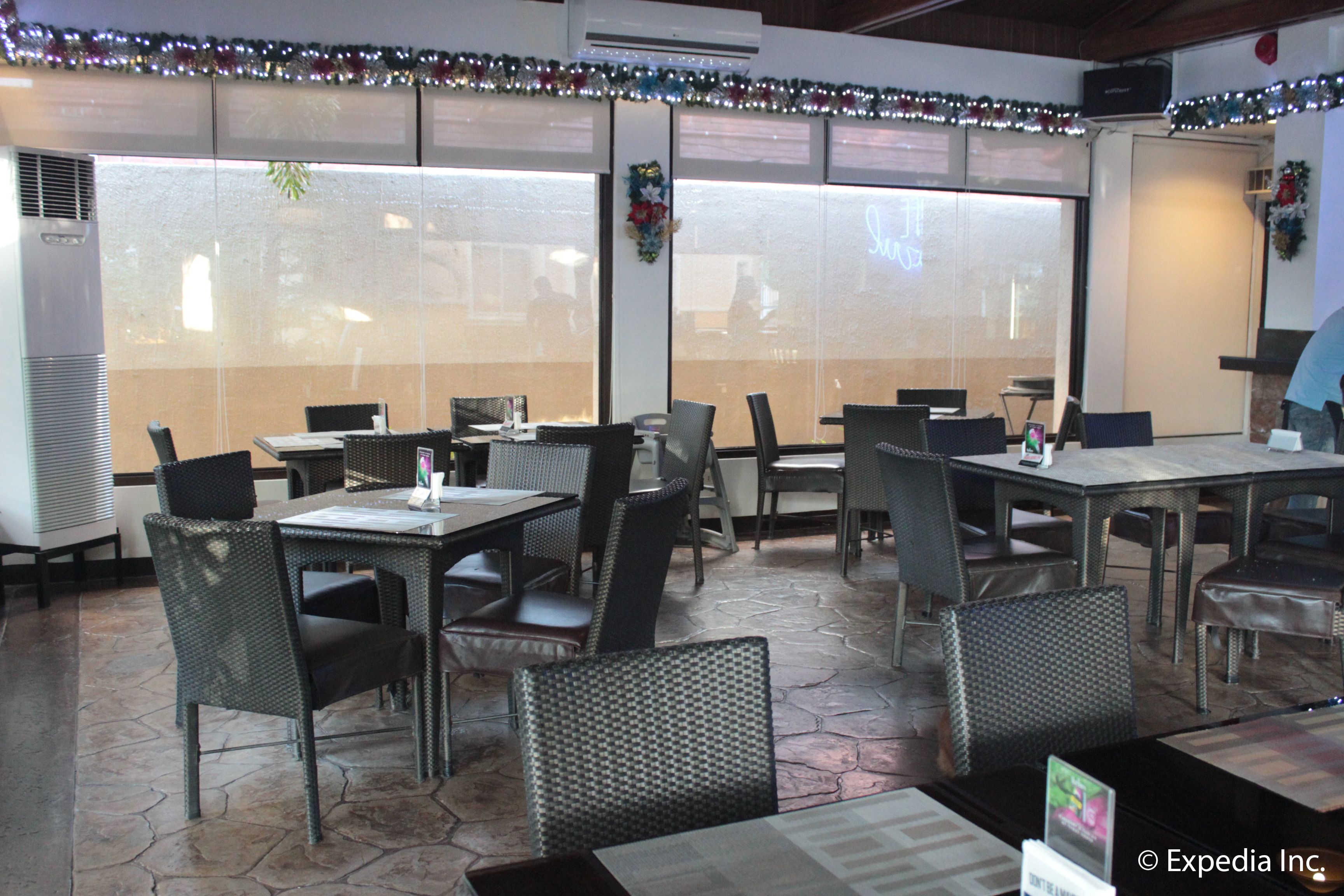 A restaurant with outdoor seating, air conditioning units, and decorative lights.