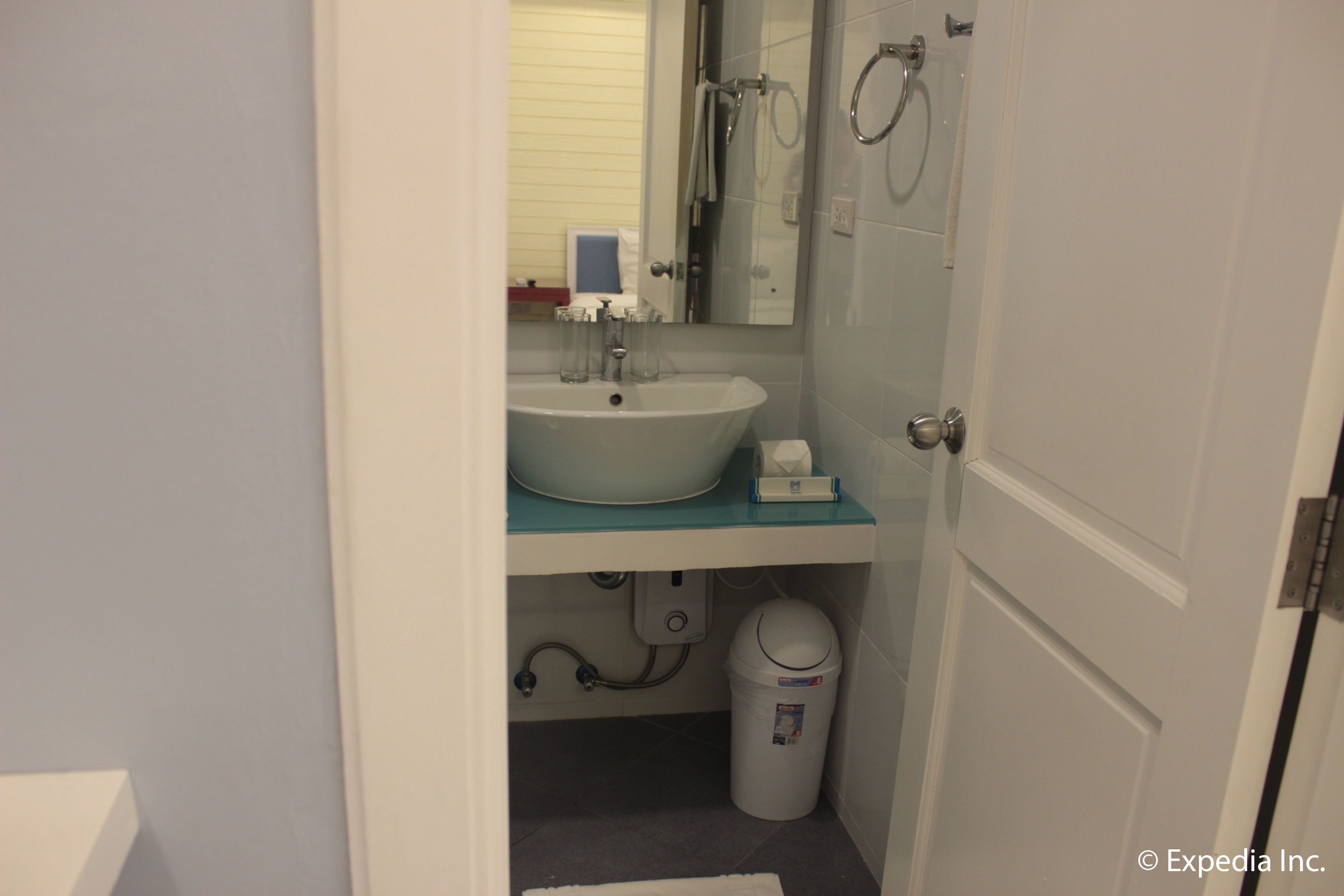 A bathroom with a white sink, a mirror, and a toilet.