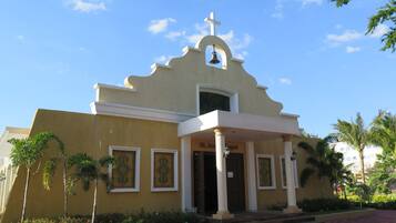 Una iglesia con un campanario, una cruz y un letrero que dice "St. Ann Chapel".