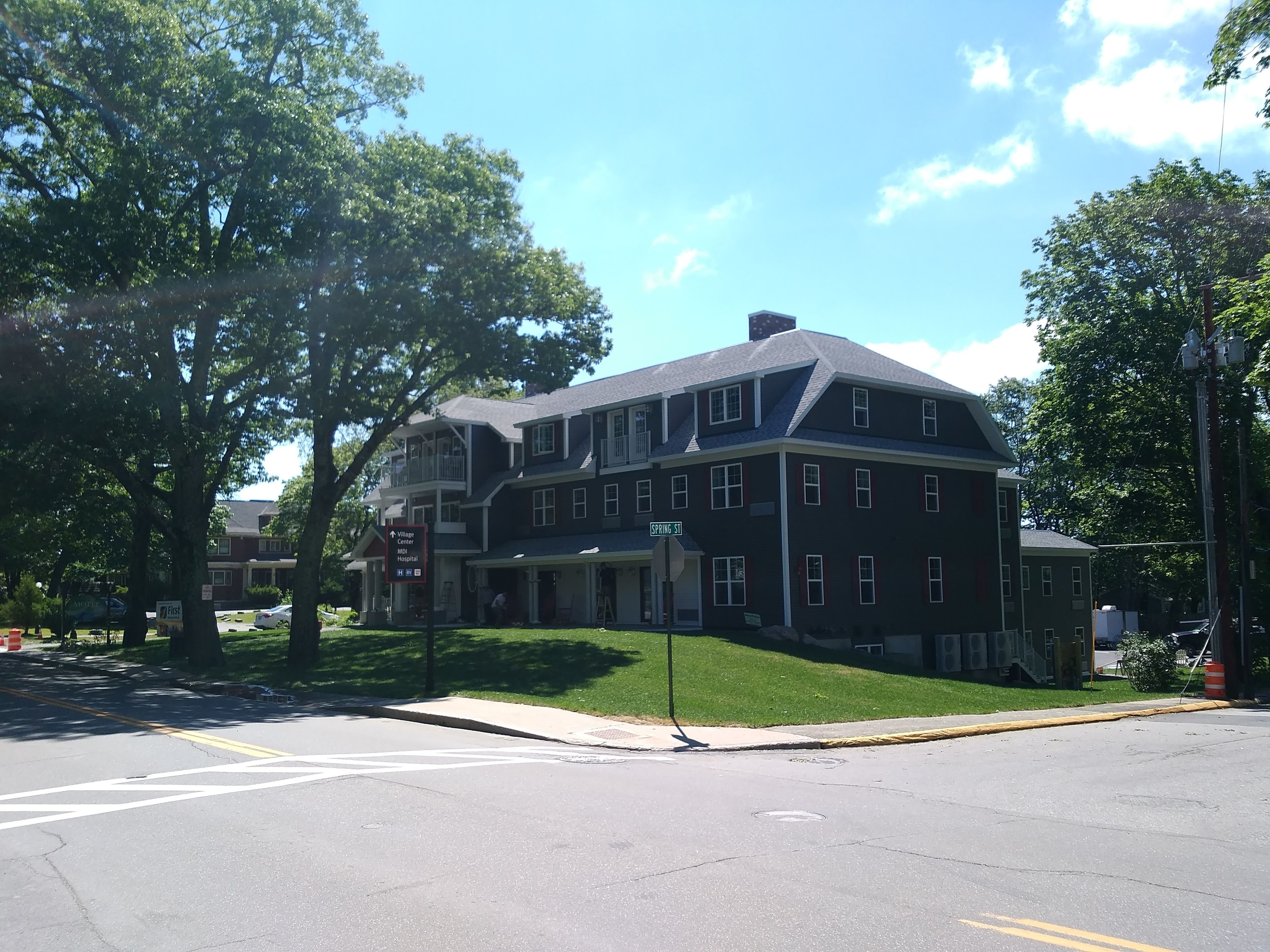 A large, two-story building with a prominent entrance and a sign indicating it is the Village Center.