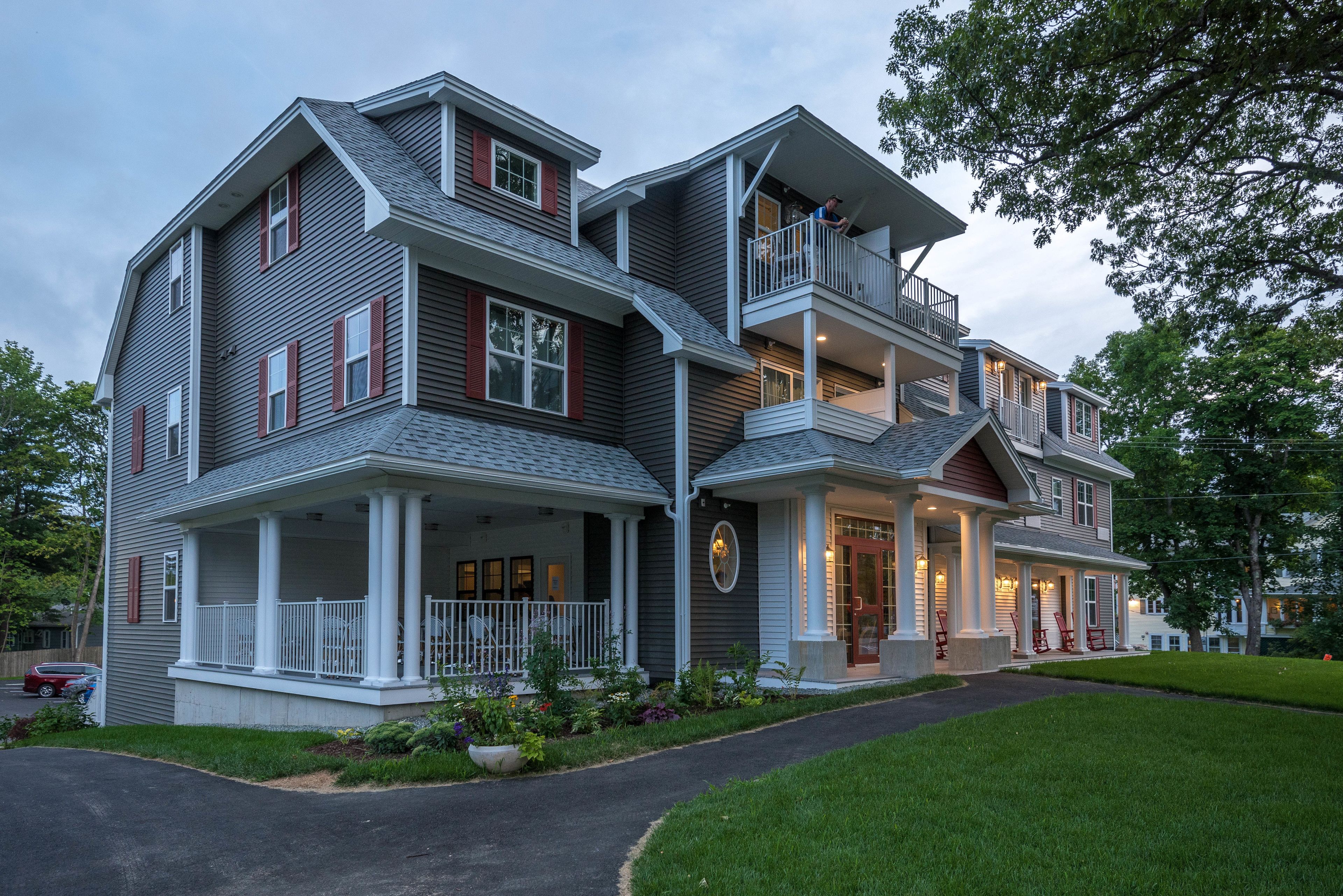 Une maison à deux étages avec un balcon, une véranda et une porte d’entrée.