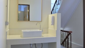 Ein Badezimmer mit Waschbecken, Spiegel und Lichtleuchte.