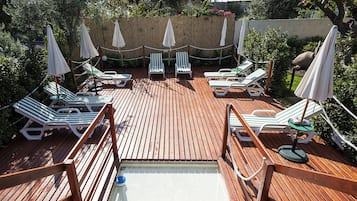 Piscina a l'aire lliure de temporada, para-sols i gandules