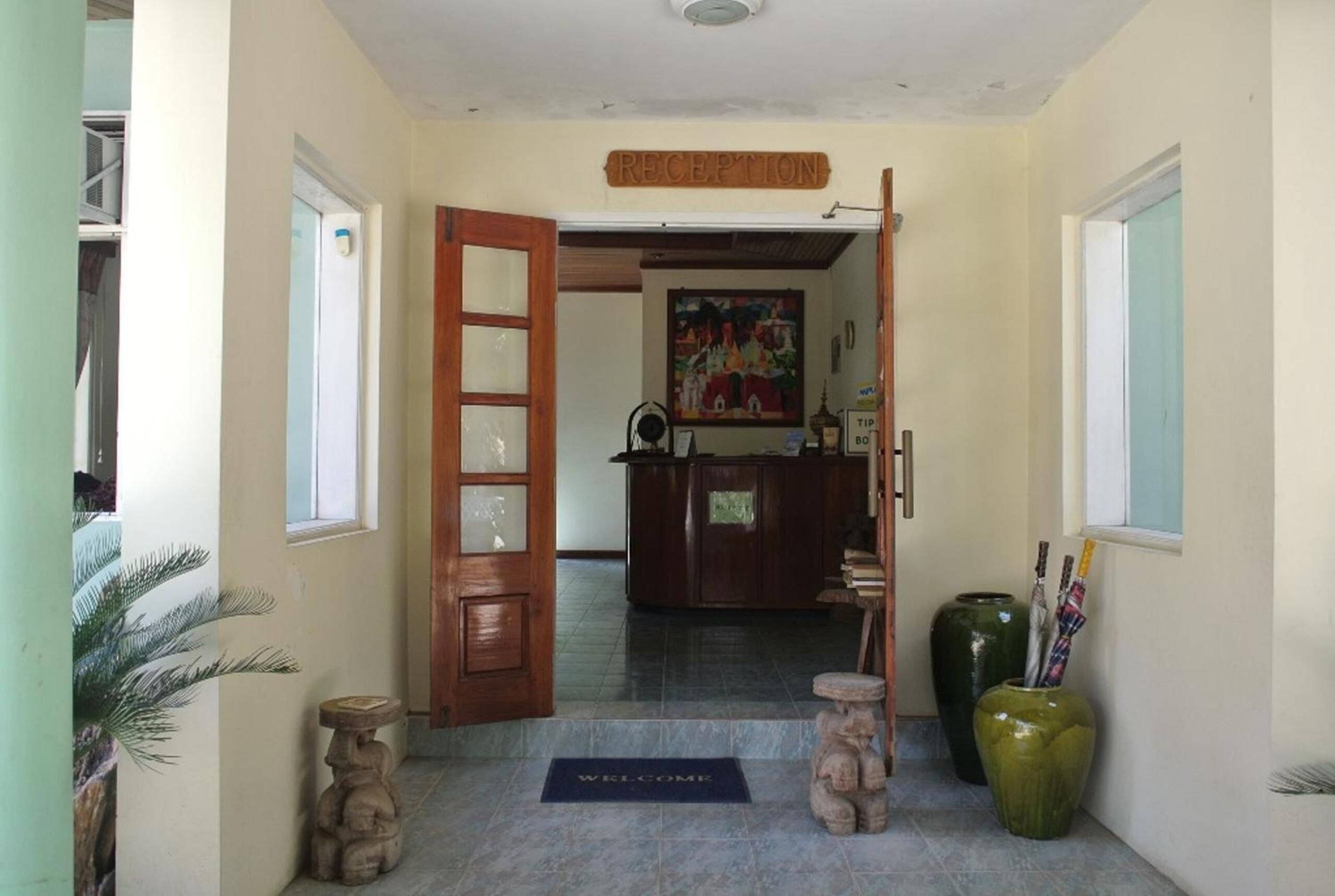 A reception area with a wooden door, a reception desk, and a welcome mat.