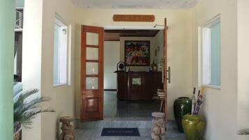 A reception area with a wooden door, a reception desk, and a welcome mat.