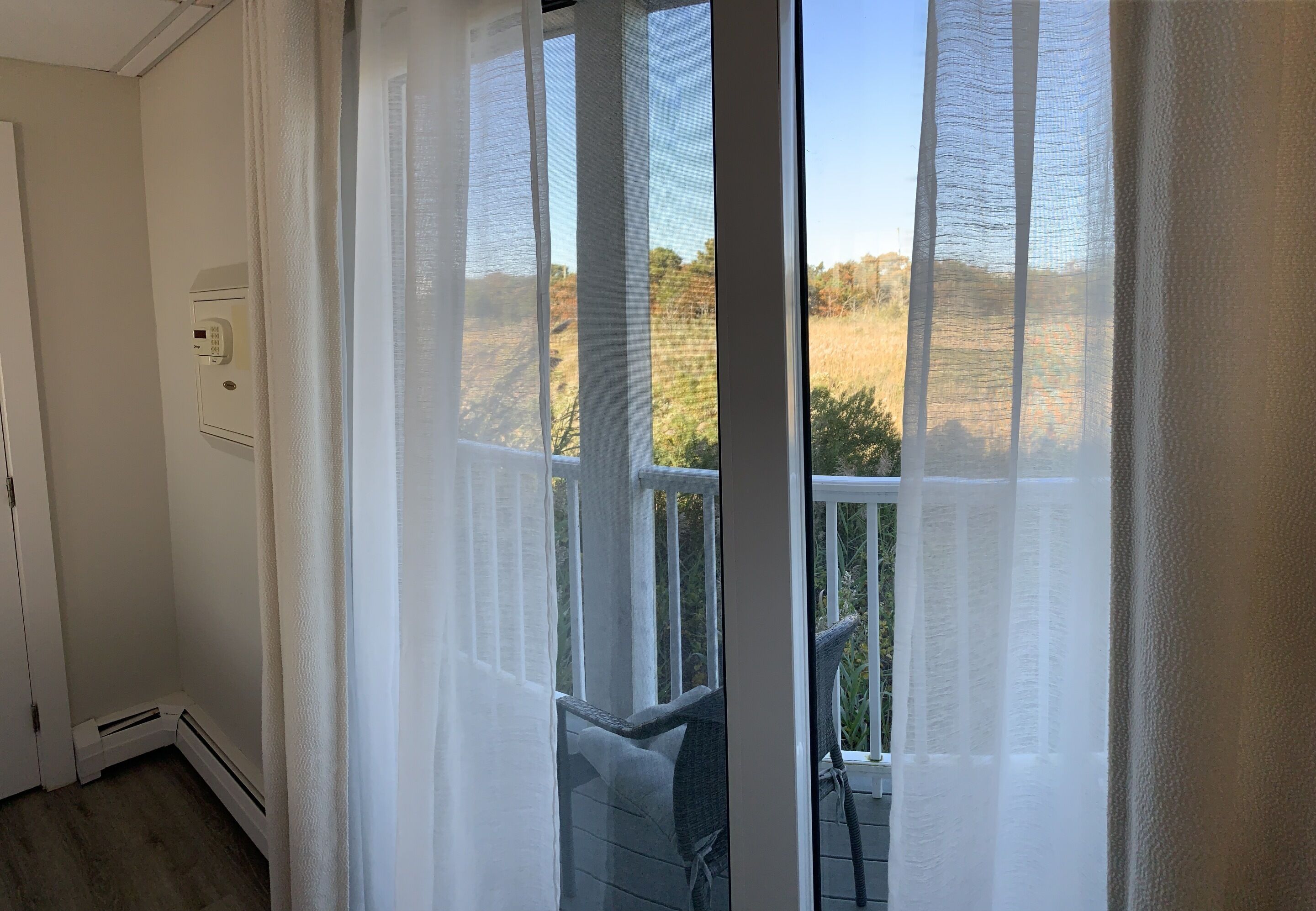 A room with a sliding glass door leading to a balcony.