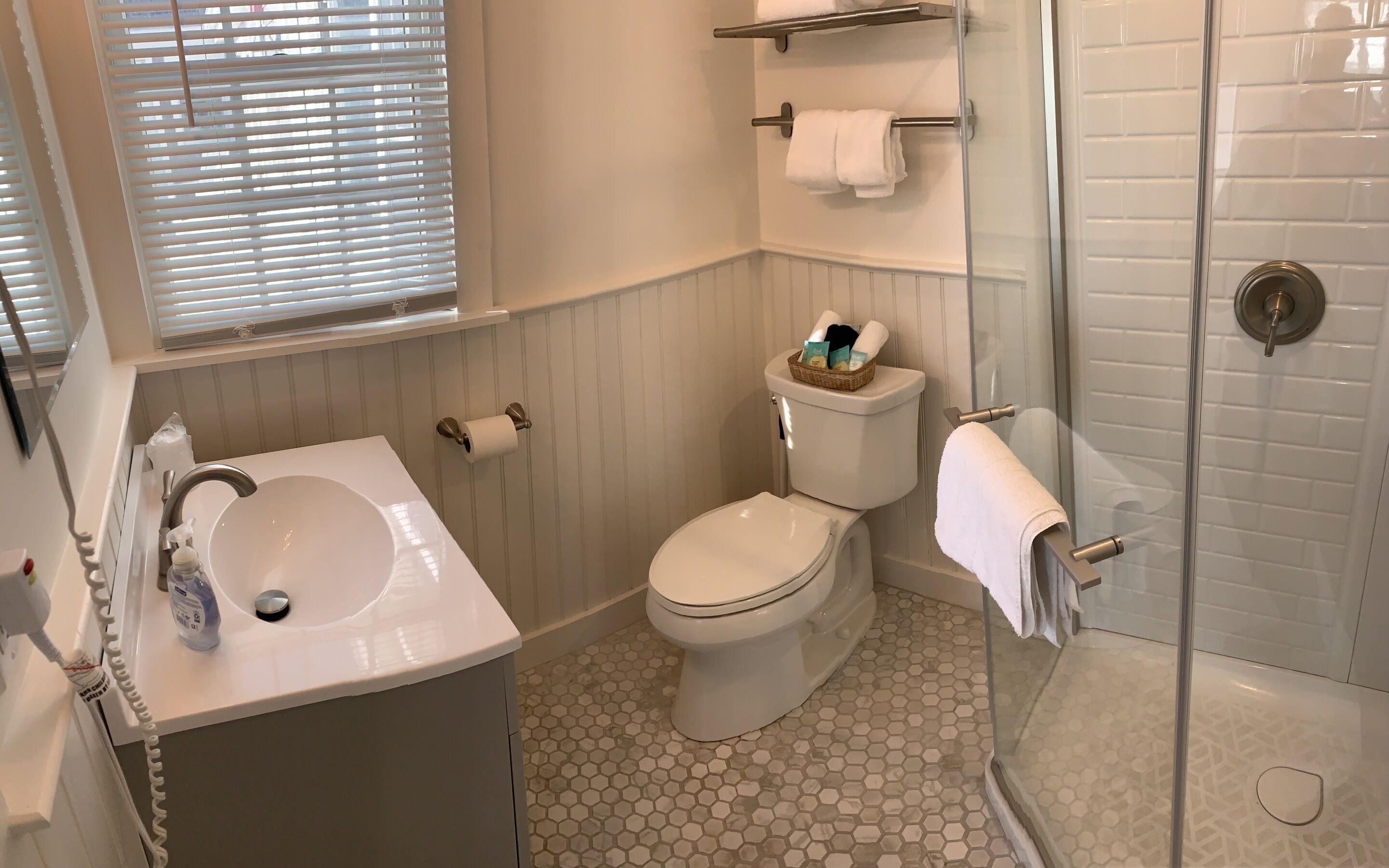 Un baño con inodoro, lavamanos y ducha.