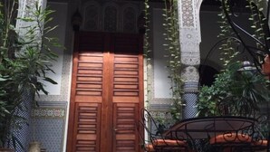 A traditional Moroccan gate with intricate tile work and a wooden door. - Riad Al Bartal (Fes)