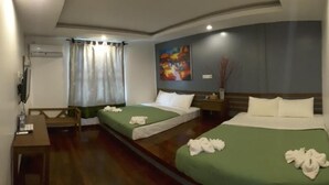 Habitación de hotel con dos camas, un escritorio, una silla, un televisor y un cuadro en la pared.