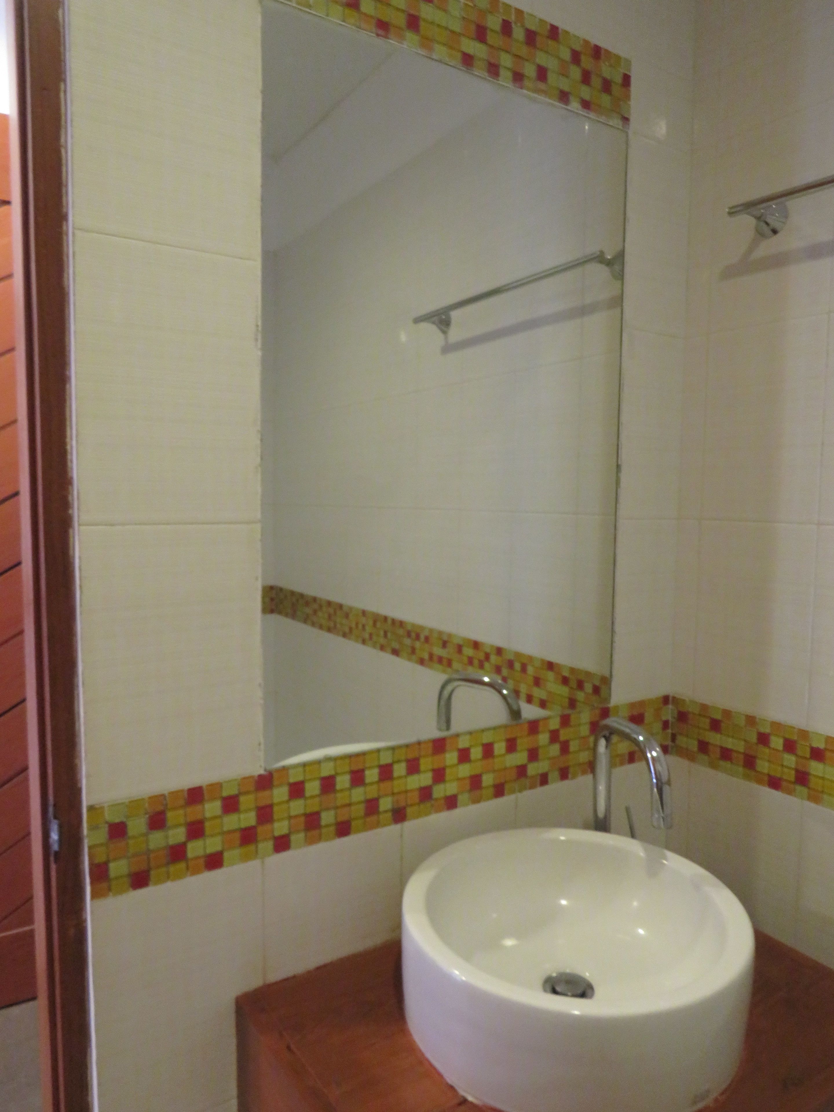 Ein Badezimmer mit Waschbecken, Spiegel und Handtuchhalter.