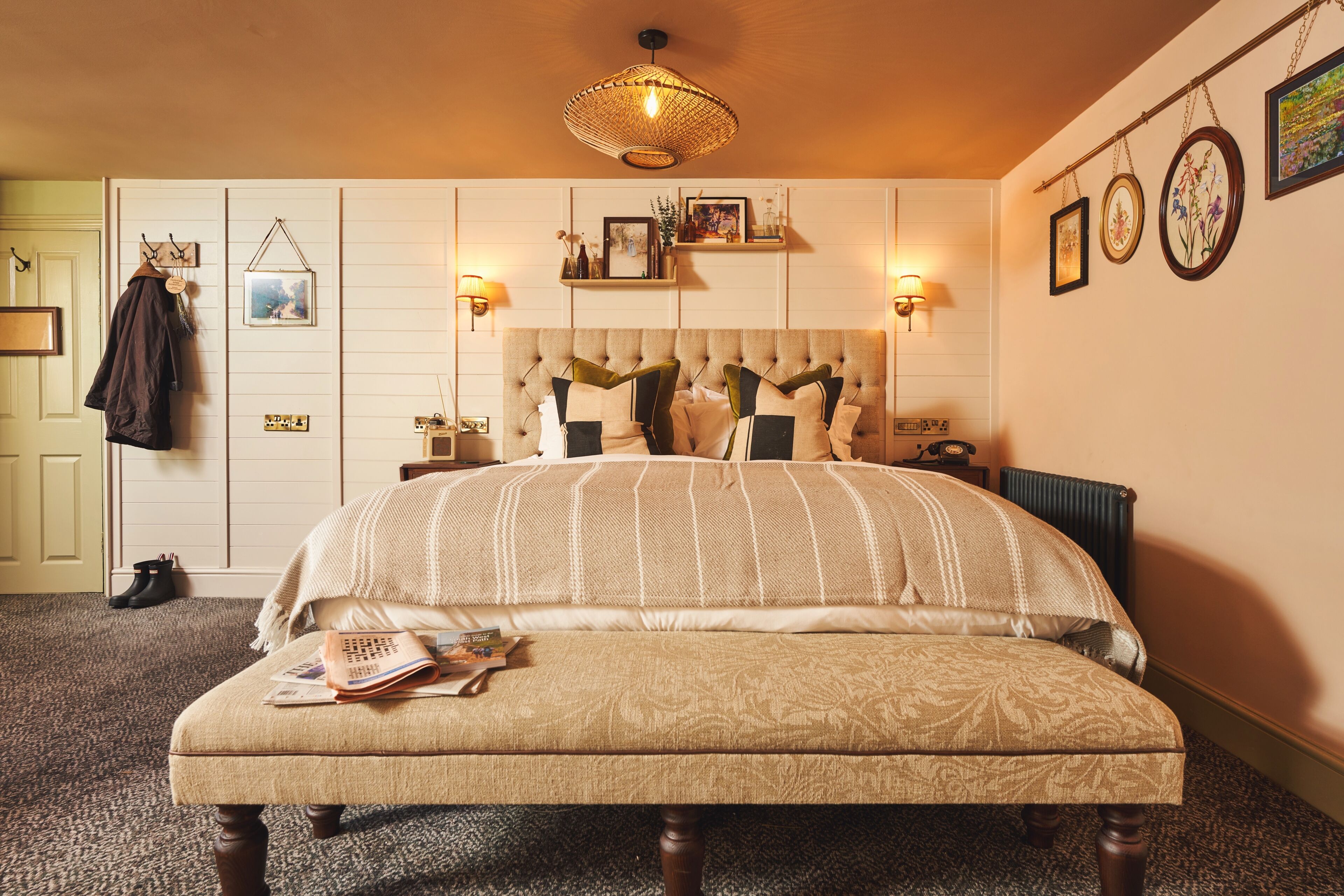 Un dormitorio con una cama grande, una mesita de noche, una lámpara y un aplique.