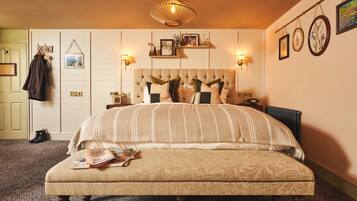 Un dormitorio con una cama grande, una mesita de noche, una lámpara y un aplique.