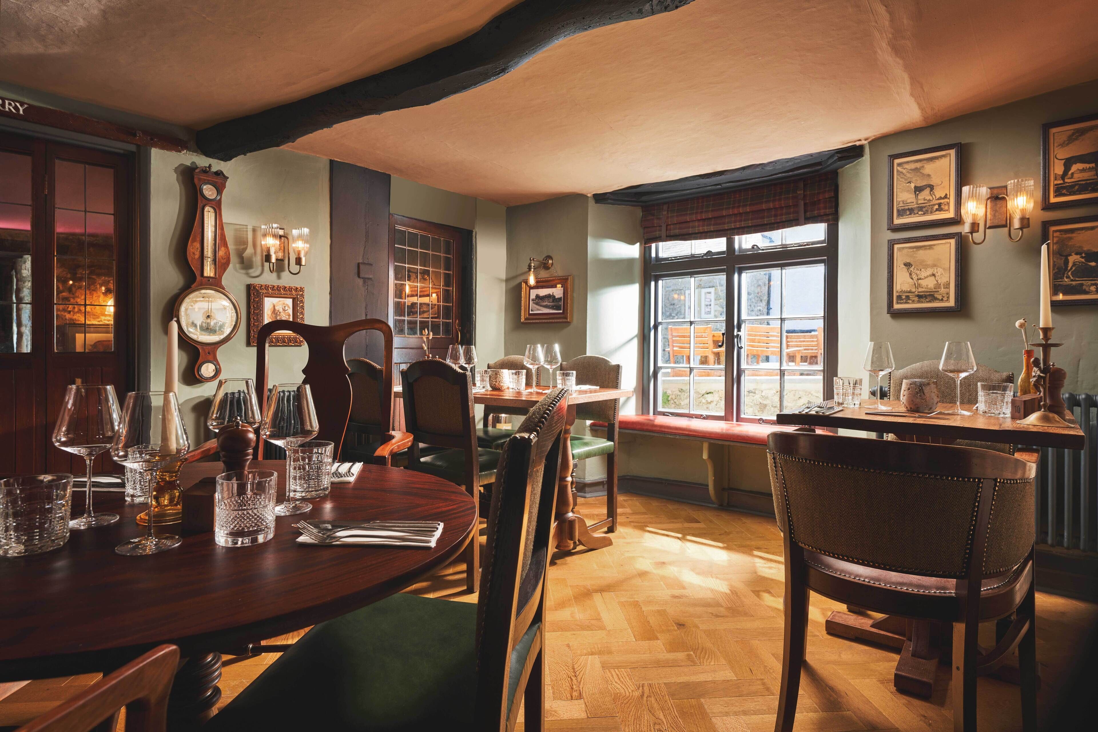 A traditional dining room with wooden furniture, a large window with a view, and wall-mounted decor.
