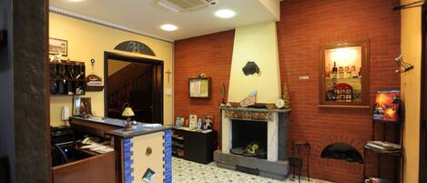 A cozy living room with a fireplace, a wooden desk, and a bookshelf.