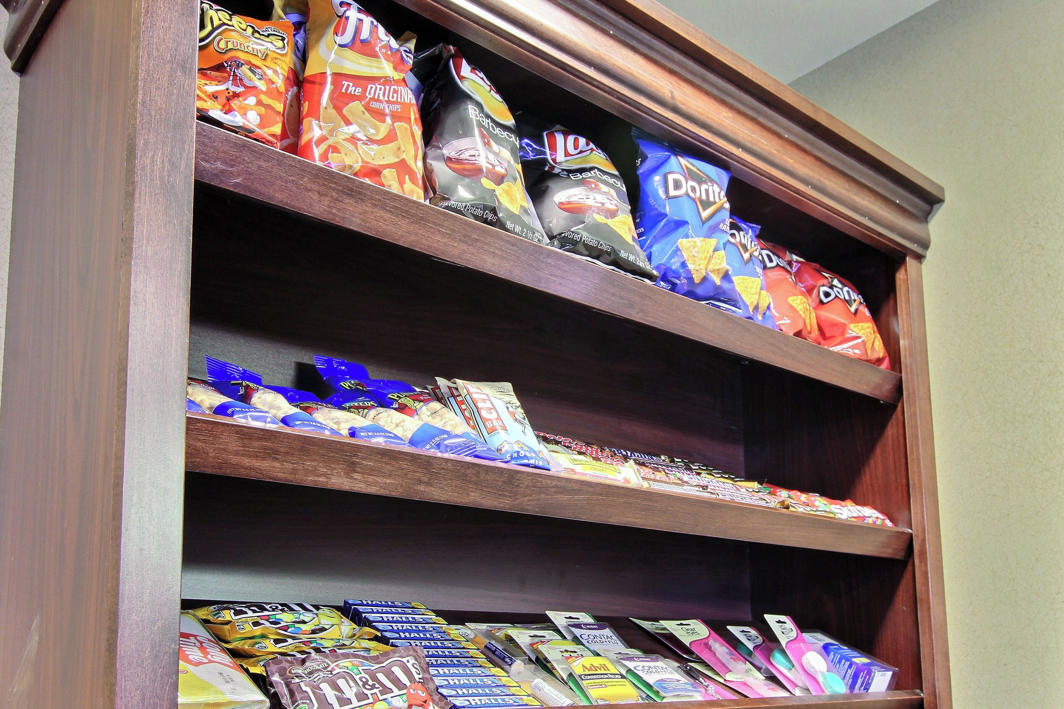 Un estante lleno de diversos aperitivos, como papas fritas y barras de chocolate.