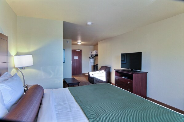 A hotel room with a bed, a TV, a desk, and a chair. - Cobblestone Hotel & Suites - Beulah (Beulah)