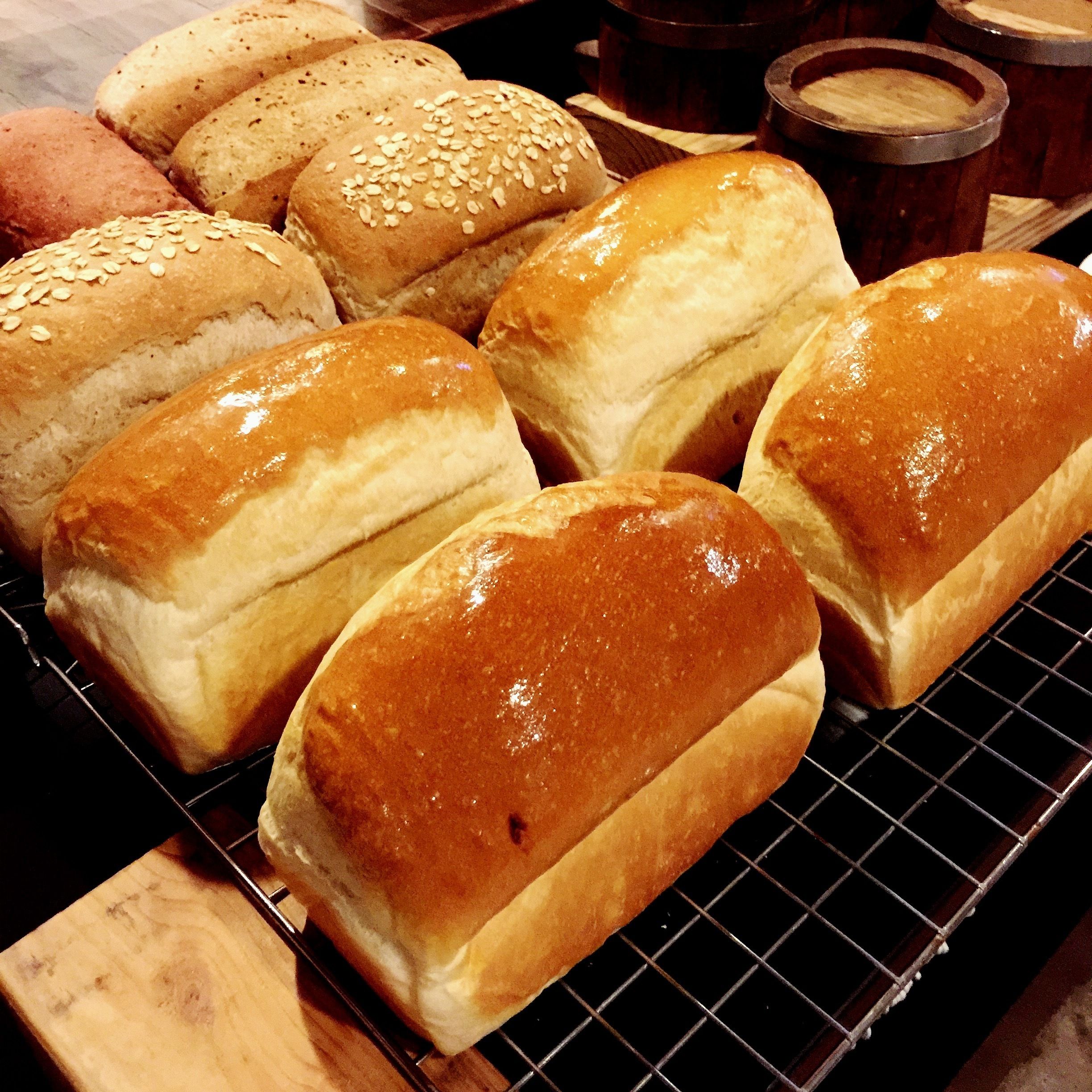A variety of breads on a cooling rack.