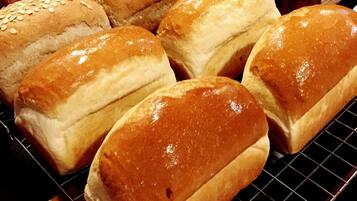A variety of breads on a cooling rack.